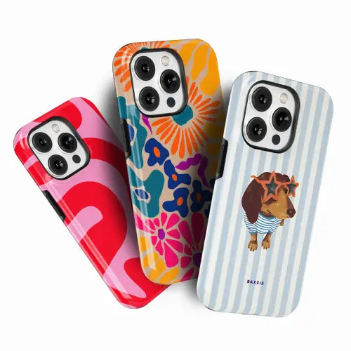 Three protective phone cases displayed on smartphone mockups against a clean white background. The left case has a bold red and pink wavy pattern, the middle case features a retro floral design in orange, blue, and pink, and the right case has light blue and white vertical stripes with a cartoon dachshund wearing sunglasses.
